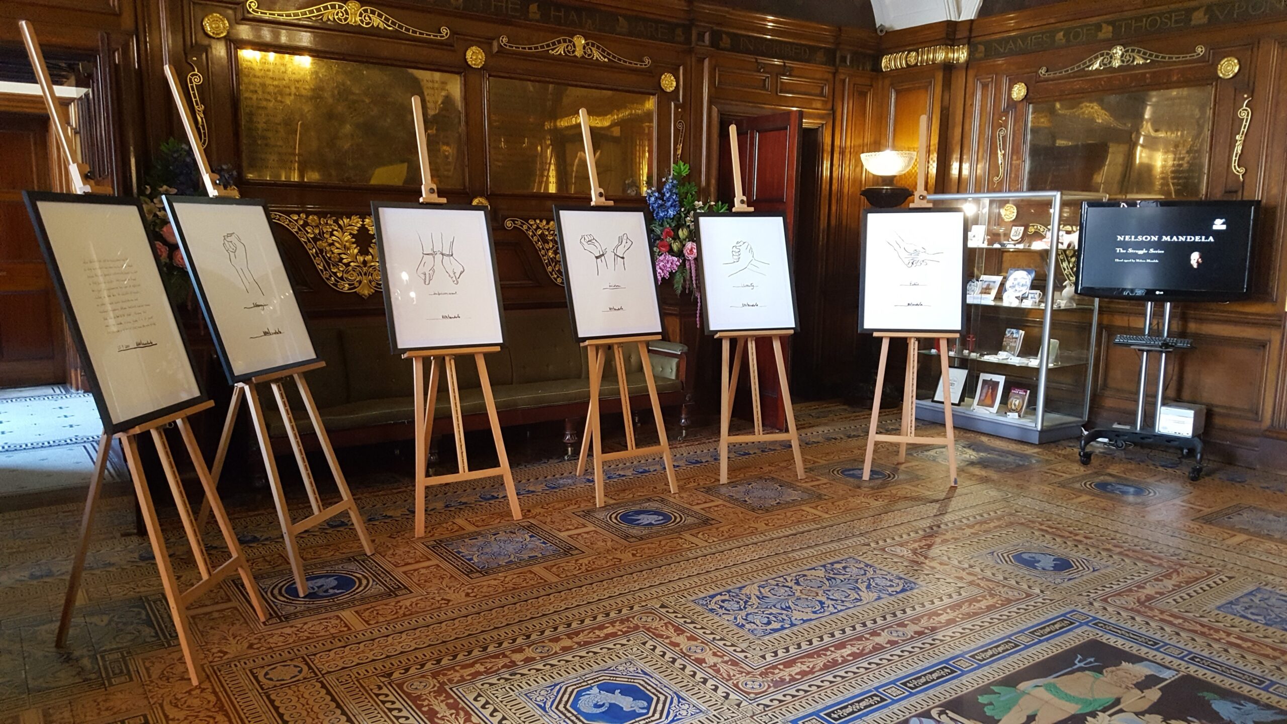 A selection of prints being displayed in a hall.